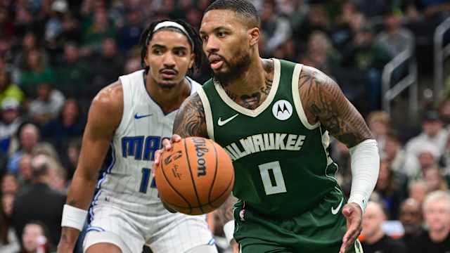 Milwaukee Bucks guard Damian Lillard (0) drives past Orlando Magic guard Gary Harris (14) 